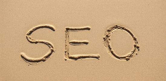 SEO written on the beach, centered in the photo, showcasing creativity.